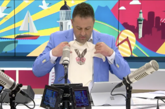 The AM Show's Duncan Garner holding a Great Full Onesie
