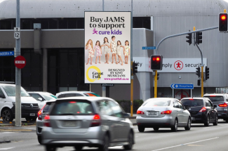 Image of the Great Full Jams billboard on the roadside at a busy intersection