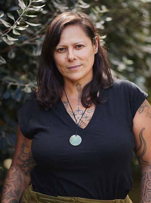 Anika Moa standing in front of trees